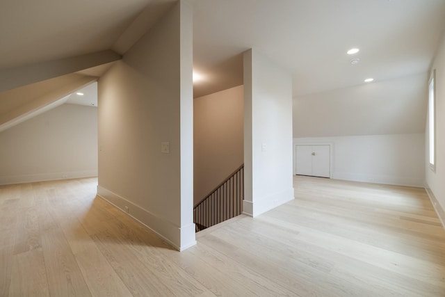 additional living space with vaulted ceiling and light wood-type flooring