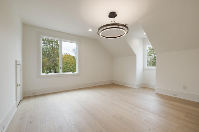 bonus room with light wood-type flooring and lofted ceiling