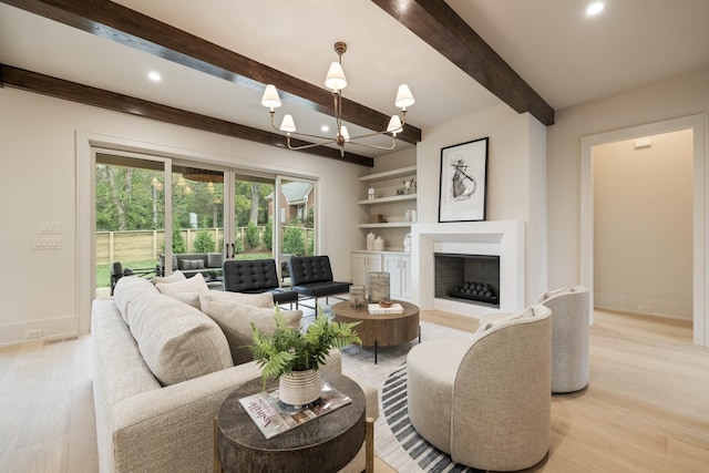 living room featuring beam ceiling, built in shelves, and light hardwood / wood-style flooring