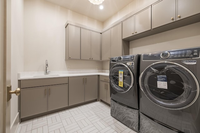 laundry room featuring cabinets, washer and clothes dryer, and sink