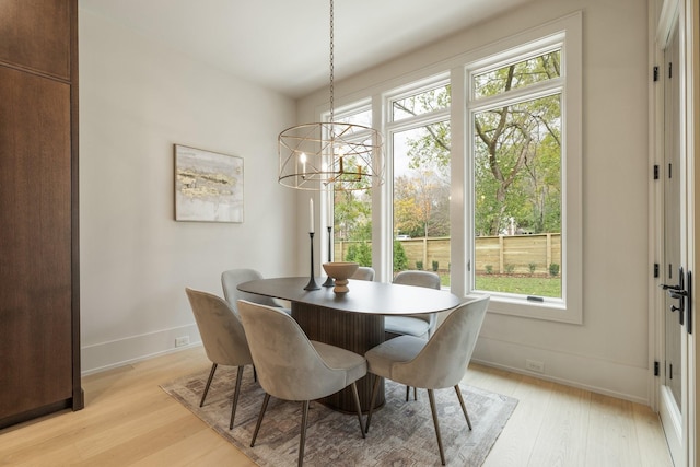 dining area featuring light hardwood / wood-style floors and a notable chandelier