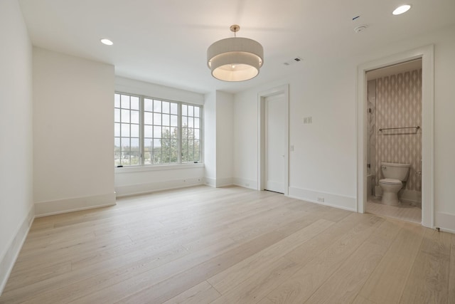 unfurnished bedroom featuring light hardwood / wood-style floors and connected bathroom