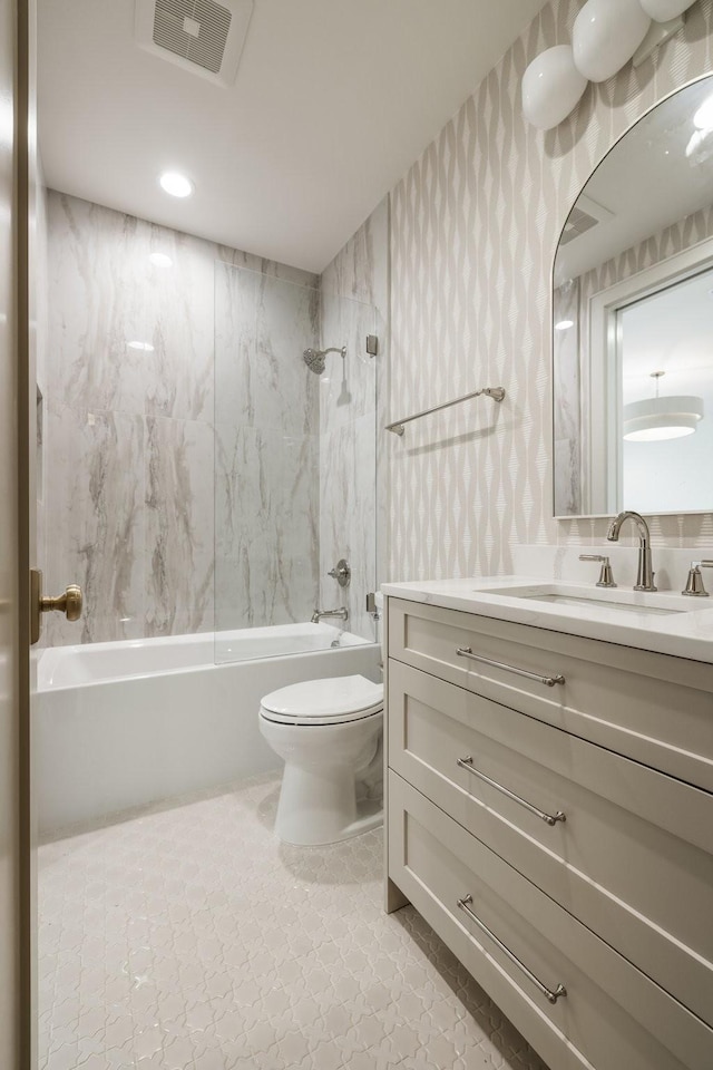 full bathroom featuring tiled shower / bath combo, toilet, and vanity