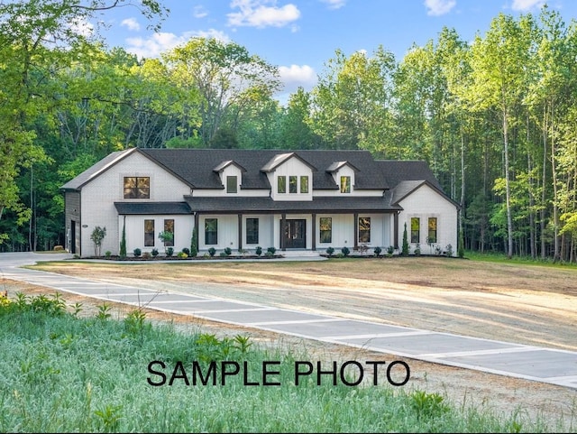 view of front of property featuring a forest view