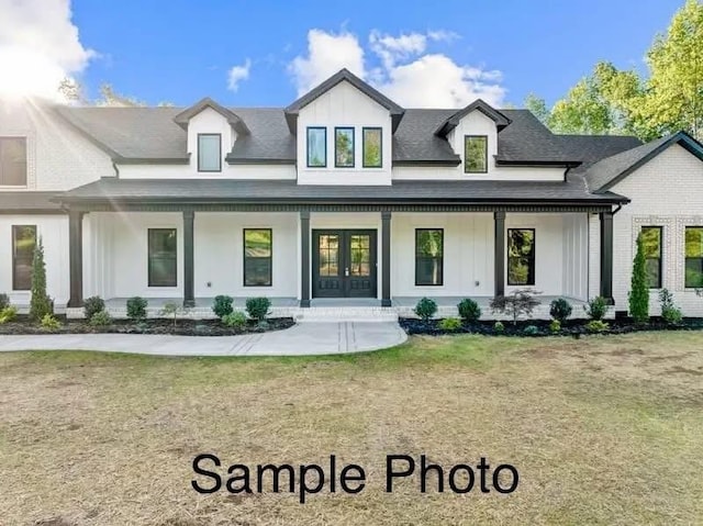 view of front of home with board and batten siding, french doors, covered porch, and roof with shingles