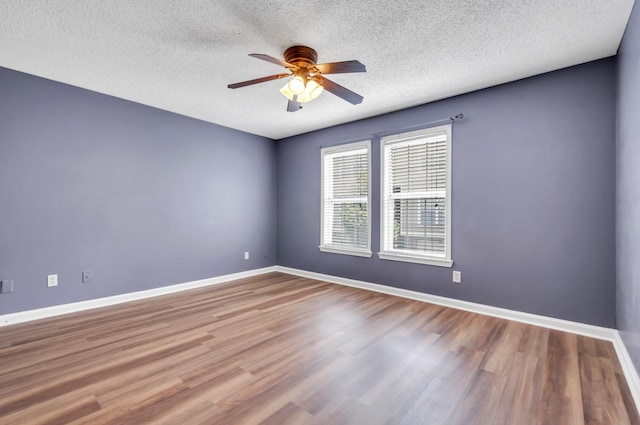 empty room with ceiling fan, wood-type flooring, and a textured ceiling