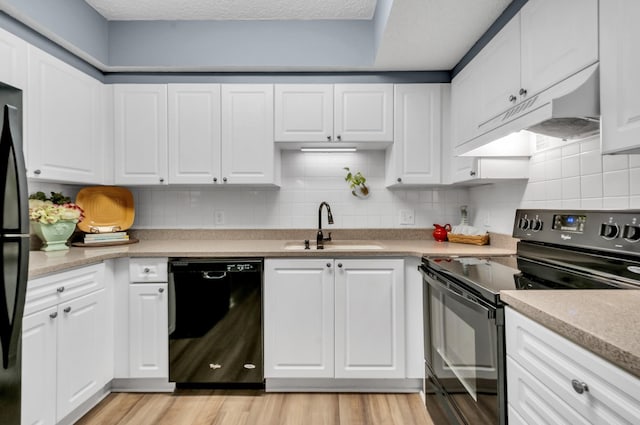 kitchen with white cabinets, sink, light hardwood / wood-style flooring, and black appliances