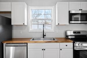 kitchen featuring white cabinetry, sink, and appliances with stainless steel finishes