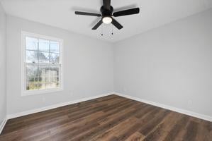 spare room featuring ceiling fan and dark wood-type flooring