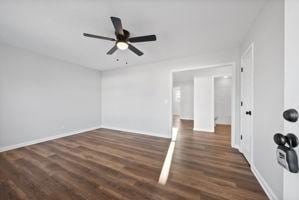 empty room featuring ceiling fan and dark wood-type flooring