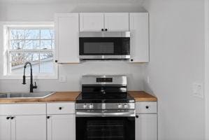 kitchen with sink, white cabinets, and stainless steel appliances