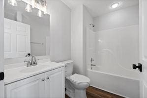 full bathroom featuring hardwood / wood-style flooring, vanity, toilet, and bathing tub / shower combination