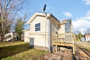 rear view of property with a lawn and a deck