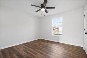 spare room featuring ceiling fan and dark wood-type flooring