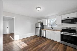 kitchen with white cabinetry, sink, dark hardwood / wood-style floors, and appliances with stainless steel finishes