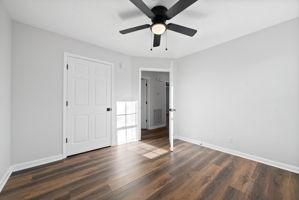 unfurnished bedroom featuring ceiling fan and dark hardwood / wood-style floors