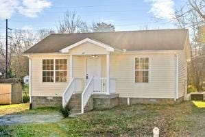 view of front of house featuring a front lawn and a storage unit