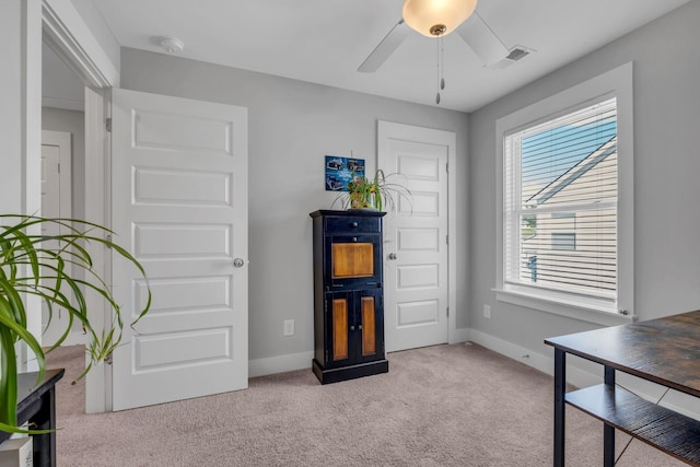 interior space with light carpet and ceiling fan