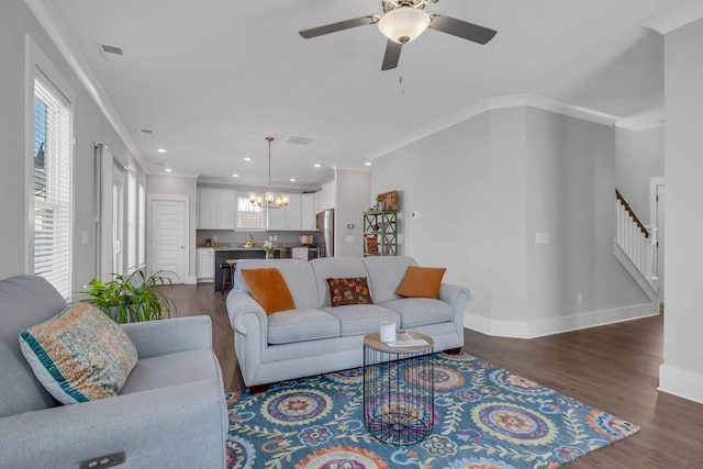 living room featuring crown molding, dark wood-type flooring, and ceiling fan with notable chandelier