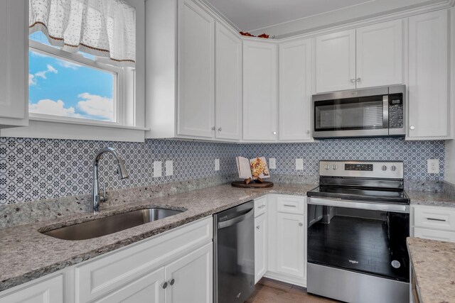 kitchen featuring white cabinets, sink, appliances with stainless steel finishes, and tasteful backsplash