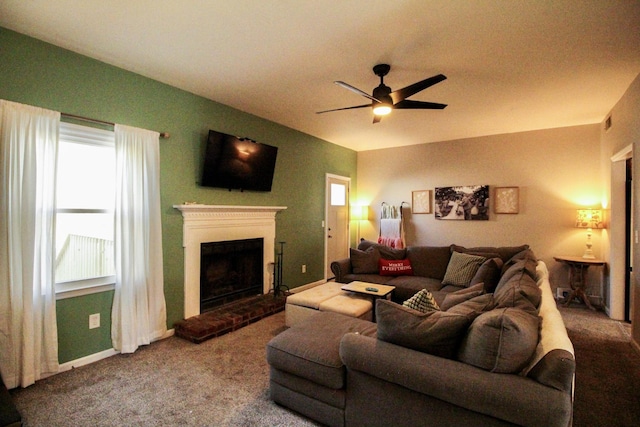 carpeted living room with a brick fireplace and ceiling fan