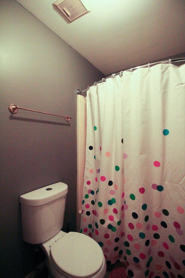 bathroom featuring toilet and a shower with curtain