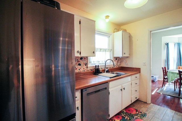 kitchen featuring white cabinetry, appliances with stainless steel finishes, sink, and light hardwood / wood-style flooring