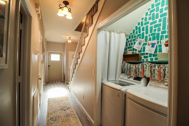 laundry room featuring wood-type flooring and washing machine and dryer