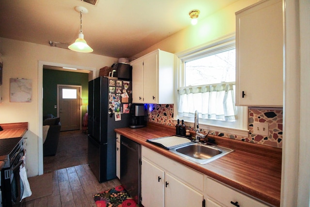 kitchen featuring pendant lighting, sink, white cabinets, backsplash, and black appliances