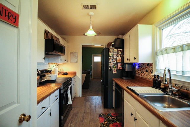 kitchen with decorative light fixtures, black appliances, and white cabinets