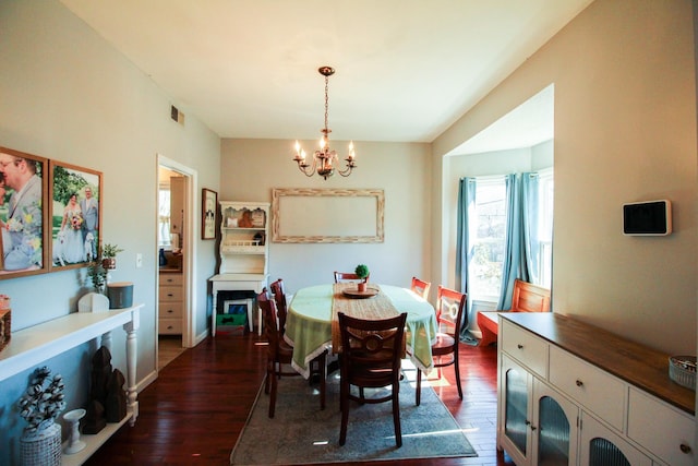 dining room featuring dark wood-type flooring and a chandelier