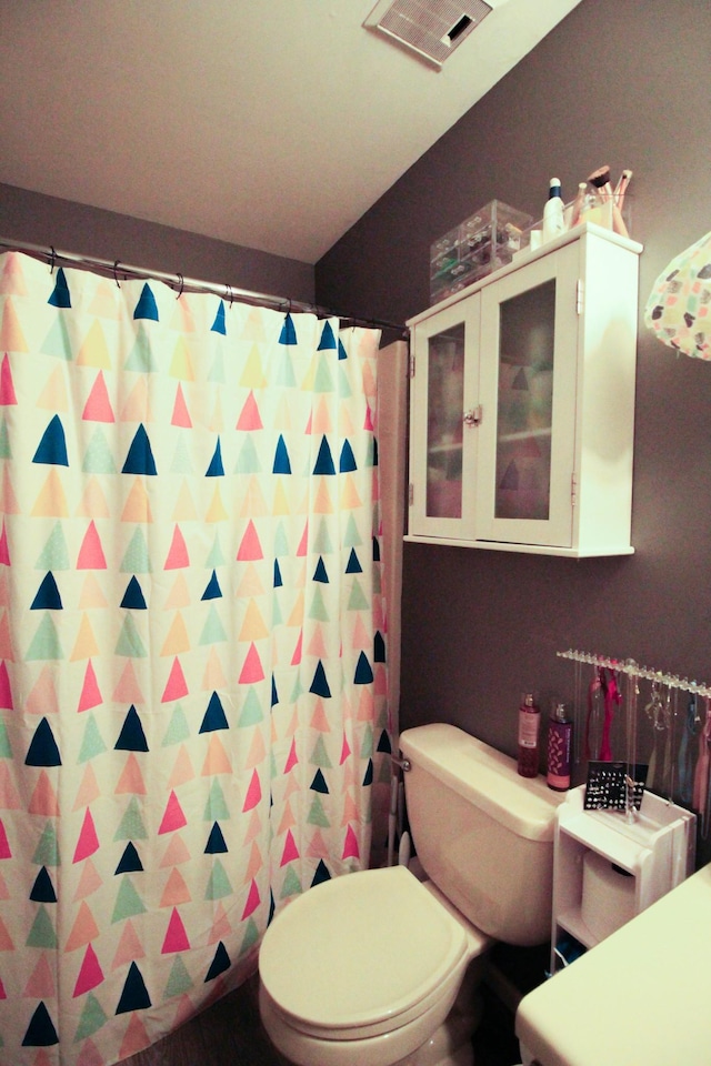 bathroom featuring curtained shower and toilet