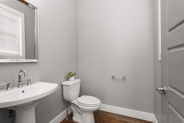 bathroom with hardwood / wood-style floors, toilet, and sink