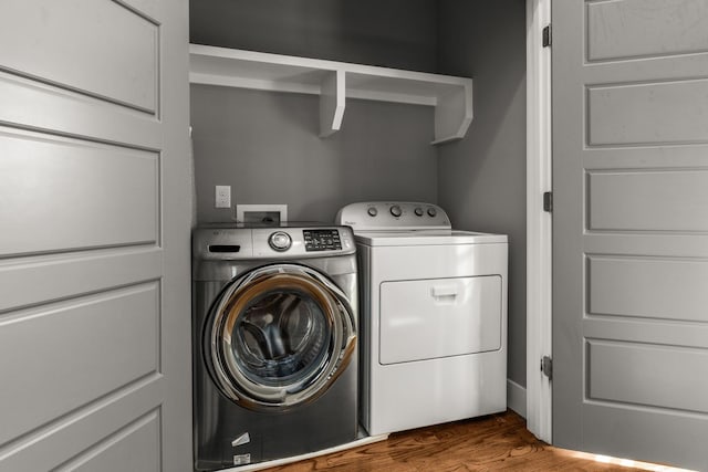 clothes washing area with hardwood / wood-style floors and independent washer and dryer