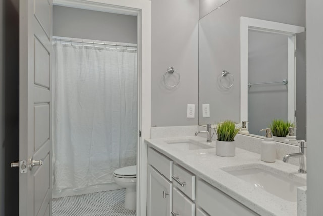 bathroom featuring tile patterned floors, vanity, toilet, and walk in shower