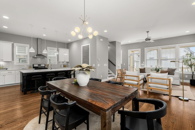 dining room featuring ceiling fan with notable chandelier, dark hardwood / wood-style floors, and sink