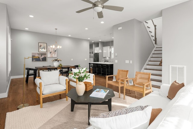 living room featuring hardwood / wood-style floors and ceiling fan with notable chandelier