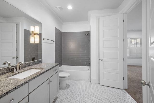 full bathroom featuring vanity, tiled shower / bath combo, and toilet