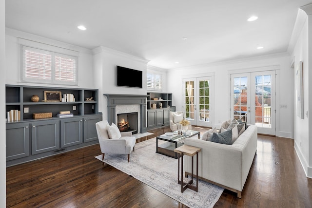 living room with a high end fireplace, french doors, dark hardwood / wood-style flooring, and crown molding