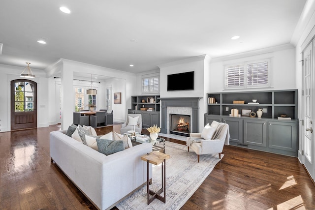 living room with dark hardwood / wood-style flooring, a fireplace, and ornamental molding