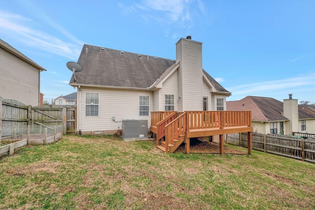 rear view of house featuring a yard, central AC unit, and a deck