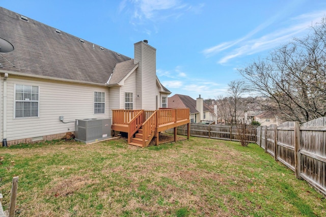 rear view of house with a yard, a deck, and central air condition unit