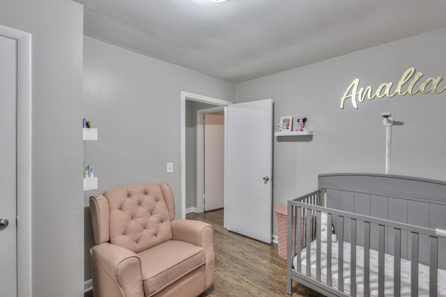 bedroom with a nursery area and hardwood / wood-style flooring