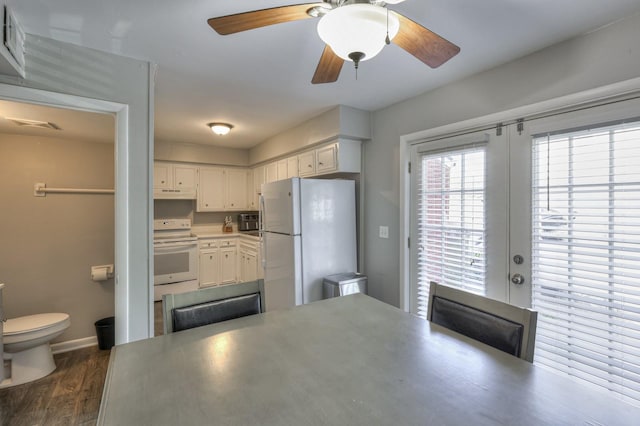 kitchen featuring french doors, white cabinets, dark wood-type flooring, and white appliances