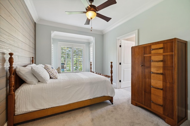 carpeted bedroom with crown molding, ceiling fan, and wooden walls