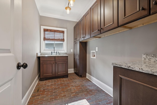 laundry room featuring cabinets, ornamental molding, sink, and hookup for a washing machine