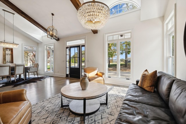 living room with a chandelier, hardwood / wood-style floors, lofted ceiling with beams, and french doors