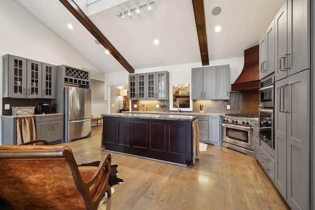 kitchen featuring gray cabinetry, a center island, custom range hood, and appliances with stainless steel finishes