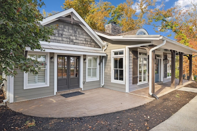 property entrance with a patio area and french doors