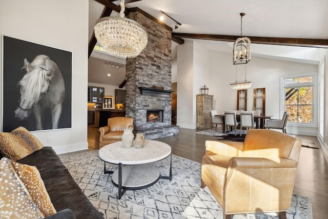 living room with rail lighting, a fireplace, beamed ceiling, light hardwood / wood-style floors, and a chandelier